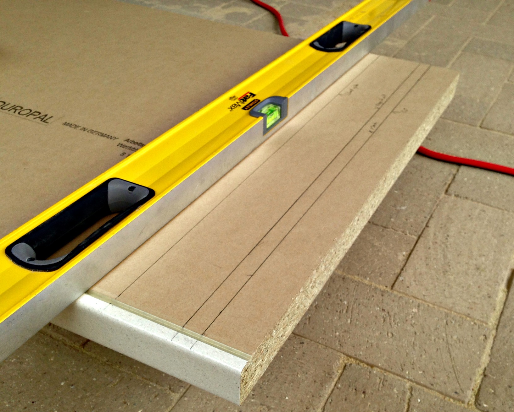 Spirit level clamped to worktop as a straight edge